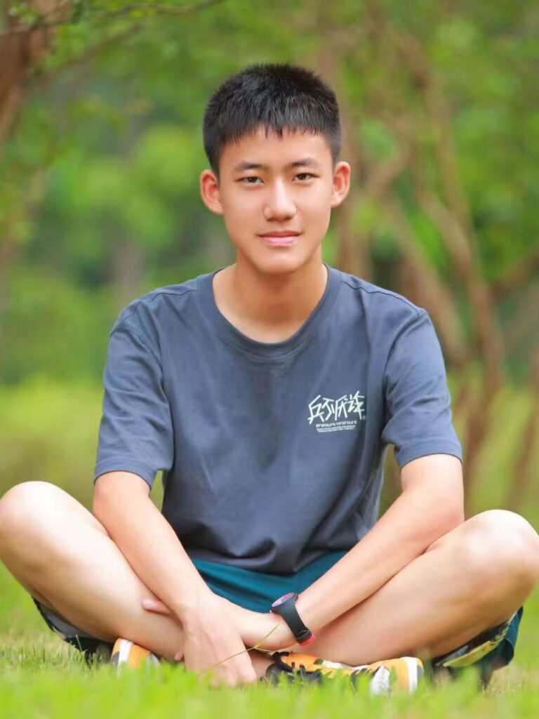 Gabriel Yang sitting on a grassland.